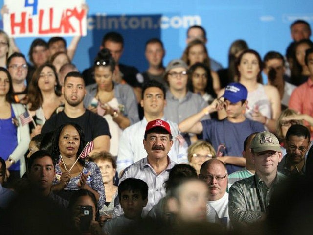 A man identified as Seddique Mateen (C-red ball cap), whose son shot and killed 49 people and injured 53 others inside the Pulse nightclub in June, sits with supporters at a rally for Democratic Presidential nominee Hillary Clinton at the Osceola Heritage Park in Kissimmee, Florida on August 8, 2016. / AFP / Gregg Newton (Photo credit should read GREGG NEWTON/AFP/Getty Images)