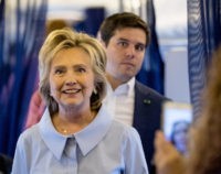 Democratic presidential candidate Hillary Clinton accompanied by traveling press secretary Nick Merrill, right, comes back to speak to members of the media on board for her first flight on a new campaign plane before taking off at the Westchester County Airport in White Plains, N.Y., Monday, Sept. 5, 2016, to travel to Cleveland Hopkins International Airport for Labor Day events. (AP Photo/Andrew Harnik)
