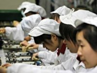 Staffs works on the production line at the Foxconn complex in the southern Chinese city of Shenzhen, Southern city in China, Wednesday, May 26, 2010. The head of the giant electronics company whose main facility in China has been battered by a string of worker suicides opened the plant's gates to scores of reporters Wednesday, hours after saying that intense media attention could make the situation worse.  (AP Photo/Kin Cheung)