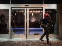 CHARLOTTE, NC - SEPTEMBER 21: A man exits a hotel lobby damaged by protestors September 21, 2016 in downtown Charlotte, NC. Protests in Charlotte began on Tuesday in response to the fatal shooting of 43-year-old Keith Lamont Scott at an apartment complex near UNC Charlotte. (Photo by Sean Rayford/Getty Images)