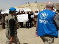 Members of the Mujahedeen-e-Khalq organization chant slogans and hold banners during a tour organized by the Iraqi government for foreign diplomats in Baghdad, Iraq, Tuesday, Sept. 11, 2012. Iraq's government has given foreign diplomats a rare look inside a refugee camp housing Iranian exiles, as Baghdad seeks international help resettling them in another country. Baghdad's Shiite-led government considers the Mujahedeen-e-Khalq a terrorist organization that is living in the country illegally. The government organized Tuesday's visit to Camp Liberty outside the capital, where 2,300 members of the group live, to speed their departure. The MEK is an opposition group to Tehran's clerical regime and cannot return to Iran. They were given sanctuary in Iraq by Saddam Hussein decades ago. (AP Photo/Hadi Mizban)