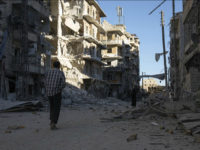 SYRIA, ALEPPO : TOPSHOT - A Syrian man walks past a heavily damaged building following air strikes on rebel-held eastern areas of Aleppo on September 24, 2016. Heavy Syrian and Russian air strikes on rebel-held eastern areas of Aleppo city killed at least 25 civilians on Saturday, the Britain-based Syrian Observatory for Human Rights said, overwhelming doctors and rescue workers. / AFP PHOTO / KARAM AL-MASRI
