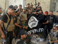 Iraqi security forces backed by Shiite and Sunni pro-government fighters celebrate as they hold a flag of the Islamic State militant group they captured in Anbar University in Ramadi, Anbar province, Iraq, Sunday, July 26, 2015. Iraqi government forces recaptured Anbar University from the Islamic State militant group Sunday after hours of fierce clashes, provincial officials said, as part of its push to reclaim territory across the embattled province. (AP Photo)