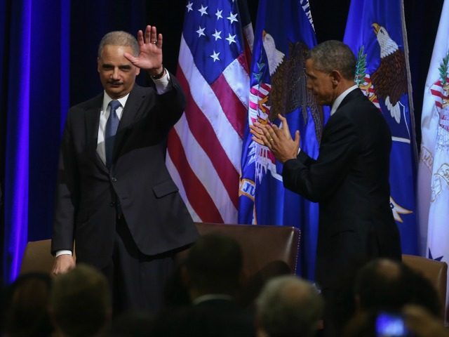 Eric Holder waves while applauded by colleagues and US President Barack Obama (R) during his portrait unveiling ceremony at the Justice Department February 27, 2015 in Washington, DC.