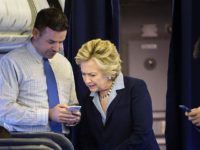 Democratic presidential nominee Hillary Clinton looks at a smart phone with national press secretary Brian Fallon on  her plane at Westchester County Airport October 3, 2016 in White Plains, New York. / AFP / Brendan Smialowski        (Photo credit should read BRENDAN SMIALOWSKI/AFP/Getty Images)