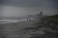 People bike on the beach ahead of hurricane Matthew in Atlantic Beach, Florida, on October 5, 2016
