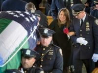Lisa Tuozzolo, wife of the late Sgt. Paul Tuozzolo is escorted by a high ranking New York Police Department officer, at the conclusion of Tuozzolo’s Mass of Christian Burial at St. Rose of Lima Catholic Church in Massapequa, N.Y.,  Thursday Nov. 10, 2016.The 19-year veteran officer was killed Nov. 4, during a gun fight in the Bronx borough of New York. (J. Conrad Williams Jr./Newsday via AP, Pool)