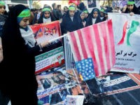 An Iranian youth burns home-made American flag outside the former US embassy in the Iranian capital Tehran on November 3, 2016, during a demonstration marking the anniversary of its storming by student protesters that triggered a hostage crisis in 1979. Thousands of Iranians took part in the demonstration, 37 years after the event that lasted for 444 days. / AFP / ATTA KENARE (Photo credit should read ATTA KENARE/AFP/Getty Images)