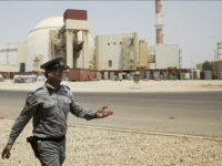 FILE - In this Aug. 21, 2010 file photo, an Iranian security officer directs media at the Bushehr nuclear power plant, with the reactor building seen in the background, just outside the southern city of Bushehr, Iran. State TV says the Guardian Council, Iran's constitutional watchdog, ratified a bill Wednesday, June 24, 2015, banning access to military sites and scientists as Tehran and world powers approach a deadline for reaching a comprehensive nuclear deal. The bill would allow for international inspections of Iranian nuclear sites within the framework of the Nuclear Non-proliferation Treaty. (AP Photo/Vahid Salemi, File)
