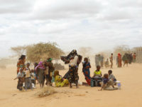 FILE - In this Friday, Aug. 5, 2011 file photo, newly arrived Somali refugees wait outside a UNHCR processing center at the Ifo refugee camp outside Dadaab, eastern Kenya, 100 kilometers (62 miles) from the Somali border. The Kenyan government is coercing refugees to quit the world's largest refugee camp and return to Somalia where they risk getting killed or forcibly recruited into the Islamic extremist group, al-Shabab, Amnesty International said Tuesday, Nov. 15, 2016. (AP Photo/Jerome Delay, File)