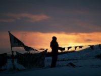 A woman watches the sunset at the Oceti Sakowin camp where people have gathered to protest the Dakota Access oil pipeline in Cannon Ball, N.D., Friday, Dec. 2, 2016. Hundreds of protesters fighting the Dakota Access pipeline have shrugged off the heavy snow, icy winds and frigid temperatures that have swirled around their large encampment. (