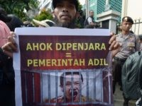 A Muslim man holds a banner that reads "Ahok in jail = fair government" during a rally outside the North Jakarta court where Jakarta's Christian governor Basuki Tjahaja Purnama is on trial in Jakarta on December 13, 2016. 
Hardline Muslims rallied on December 13 under heavy police guard outside the Indonesian courthouse where Jakarta's Christian governor Purnama is standing trial in a high-profile blasphemy case that has gripped national attention. / AFP / Adek BERRY        (Photo credit should read ADEK BERRY/AFP/Getty Images)