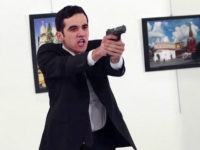 ADDS THE NAME OF THE GUNMAN - A man identified as Mevlut Mert Altintas holds up a gun after shooting Andrei Karlov, the Russian Ambassador to Turkey, at a photo gallery in Ankara, Turkey, Monday, Dec. 19, 2016. Shouting "Don't forget Aleppo! Don't forget Syria!" Altintas fatally shot Karlov in front of stunned onlookers at a photo exhibit. Police killed the assailant after a shootout. (AP Photo/Burhan Ozbilici)