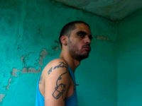 Danilo Maldonado, better known as El Sexto, stands at the entrance of his home after being released from jail, in Havana, Cuba, Tuesday, Oct. 20, 2015. Maldonado was freed after 10 months behind bars for attempting to release two pigs painted with the names of Raul and Fidel Castro, the country's current president and former leader. (AP Photo/Desmond Boylan)