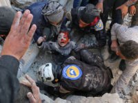 TOPSHOT - Syrian civil defence volunteers, known as the White Helmets, rescue a boy from the rubble following a reported barrel bomb attack on the Bab al-Nairab neighbourhood of the northern Syrian city of Aleppo on November 24, 2016. / AFP / AMEER ALHALBI        (Photo credit should read AMEER ALHALBI/AFP/Getty Images)