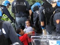 Italian police officers surround a family of migrants during an operation to remove them from the Italian-French border in the Italian city of Ventimiglia on June, 16, 2015.  Italy and France engaged in a war of words as a standoff over hundreds of Africans offered a graphic illustration of Europe's migration crisis. Italian Interior Minister Angelino Alfano described images of migrants perched on rocks at the border town of Ventimiglia after being refused entry to France as a "punch in the face for Europe."  AFP PHOTO / JEAN CHRISTOPHE MAGNENET        (Photo credit should read JEAN CHRISTOPHE MAGNENET/AFP/Getty Images)