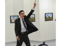 FILE - In this Monday, Dec. 19, 2016 file photo, Mevlut Mert Altintas shouts after shooting Andrei Karlov, right, the Russian ambassador to Turkey, at an art gallery in Ankara, Turkey. At first, AP photographer Burhan Ozbilici thought it was a theatrical stunt when a man in a dark suit and tie pulled out a gun during the photography exhibition. The man then opened fire, killing Karlov. (AP Photo/Burhan Ozbilici)