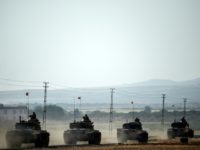 Turkish Army tanks drive to the Syrian Turkish border town of Jarabulus on August 25, 2016