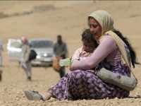 A displaced woman and child from the minority Yazidi sect, fleeing violence from forces loyal to the Islamic State in Sinjar town, rest as they make their way towards the Syrian border, on the outskirts of Sinjar mountain, near the Syrian border town of Elierbeh of Al-Hasakah Governorate August 10, 2014. Islamic State militants have killed at least 500 members of Iraq's Yazidi ethnic minority during their offensive in the north, Iraq's human rights minister told Reuters on Sunday. The Islamic State, which has declared a caliphate in parts of Iraq and Syria, has prompted tens of thousands of Yazidis and Christians to flee for their lives during their push to within a 30-minute drive of the Kurdish regional capital Arbil. Picture taken August 10, 2014. Photo: REUTERS/Rodi Said