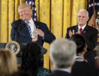 President Donald Trump, accompanied by Vice President Mike Pence, right, smiles as he takes the podium for a White House senior staff swearing in ceremony in the East Room of the White House, Sunday, Jan. 22, 2017, in Washington. (AP Photo/Andrew Harnik)