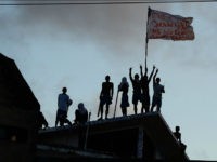 Prisioners atop the roof of the compound celebrate the transfer of their leaders after a negotiation with the police at the Alcacuz Penitentiary, near Natal, Rio Grande do Norte, on January 16, 2017. Authorities thought inmates at the Alcacuz jail near the northeastern city of Natal were under control following the quelling of a deadly riot that broke out Saturday, until some climbed to the roof on Monday. On Sunday, police had stormed the prison and ended a night-long riot. They found 26 prisoners dead, most of them beheaded, officials said. / AFP / ANDRESSA ANHOLETE (Photo credit should read ANDRESSA ANHOLETE/AFP/Getty Images)