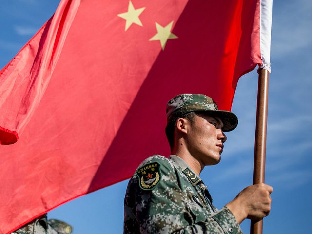 OMSK, RUSSIA - AUGUST 5, 2016: China's serviceman carries a Chinese flag during the opening ceremony for the Maintenance Battalion competition among maintenance units in the village of Cheryomushki as part of the 2016 Army Games, an international event organized by the Russian Defense Ministry. Sergei Bobylev/TASS (Photo by Sergei Bobylev\TASS via Getty Images)