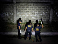 This picture taken on January 5, 2017, shows policemen investigating a crime scene where a woman was shot dead by unidentified gunmen in Manila. People going to mass at one of the most famous churches in the Philippine capital over Christmas were met by a disturbing sight: poster-size pictures of Filipinos dying in pools of blood. The shock Baclaran church exhibit was part of a campaign by one of the nation's oldest and most powerful institutions to stop the killings under President Rodrigo Duterte's war against drugs, which has claimed about 6,000 thousand lives. / AFP / NOEL CELIS / TO GO WITH AFP STORY PHILIPPINES-CRIME-RIGHTS-CATHOLIC-CHURCH,FOCUS BY CECIL MORELLA (Photo credit should read NOEL CELIS/AFP/Getty Images)