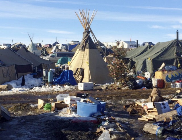 In this Thursday, Feb. 16, 2017, photo, debris is piled on the ground awaiting pickup by cleanup crews at the Dakota Access oil pipeline protest camp in southern North Dakota near Cannon Ball. The camp is on federal land, and authorities have told occupants to leave by Wednesday, Feb. 22 in advance of spring flooding. (AP Photo/Blake Nicholson)