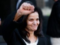 Rasmea Odeh raises her fist as she leaves federal court in Detroit Thursday, March 12, 2015. A judge sentenced the Chicago activist to 18 months in federal prison Thursday for failing to disclose her convictions for bombings in Israel when she applied to be a U.S. citizen. Odeh, 67, also was stripped of her citizenship and eventually will be deported. But she will remain free while she appeals the case. (AP Photo/Paul Sancya)