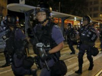 Police officers run toward protesters to try to disperse them outside the Chinese central government's liaison office in Hong Kong, Sunday, Nov. 6, 2016. Thousands of people protested in Hong Kong on Sunday, demanding that China's central government stay out of a political dispute in the southern Chinese city after Beijing indicated that it would intervene to deter pro-independence advocates. Police used pepper spray and batons to contain some of the demonstrators, arresting two. (AP Photo/Vincent Yu)