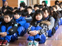 OGA, JAPAN - MARCH 17: Students at the Hokuyou Elementary School listen to instructions of the officials during a missile evacuation drill on Friday, March 17, 2017, in Kitaura, Oga, Akita Prefecture, Japan. During the drill, around 50 kids were instructed to walk slowly inside of a school gym, as if a missile had hit the the ground nearby. After a loud siren, people are instructed through a loudspeaker to move to safer ground in the school. People participated in the first missile evacuation drill organized by the Akita prefectural office and Oga city to prepare people in the event of a North Korean Missile strike on Japan. Recently, Three of four missiles fired by North Korea may have fallen into Japan's Exclusive Economic Zone and the Japanese government has lodged a strong protest against North Korea. (Photo by Richard Atrero de Guzman/Anadolu Agency/Getty Images)