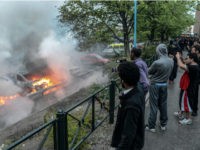 Bystanders take photos of a row of burning cars in the Stockholm suburb of Rinkeby after youths rioted in several different suburbs around Stockholm, Sweden for a fourth consecutive night on May 23, 2013. In the suburb of Husby, where the riots began on Sunday in response to the fatal police shooting of a 69-year-old machete-wielding man, 80 percent of residents are immigrants and the unrest has highlighted Sweden's failure to integrate swathes of its immigrant population, but in this small, consensus-driven country, there was little agreement on how to solve the problem.   AFP PHOTO /SCANPIX SWEDEN/ FREDRIK SANDBERG     SWEDEN OUT