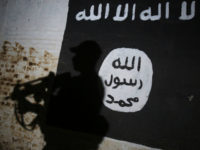 A member of the Iraqi forces walks past a mural bearing the logo of the Islamic State (IS) group in a tunnel that was reportedly used as a training centre by the jihadists, on March 1, 2017, in the village of Albu Sayf, on the southern outskirts of Mosul. Iraqi forces launched a major push on February 19 to recapture the west of Mosul from the Islamic State jihadist group, retaking the airport and then advancing north. AHMAD AL-RUBAYE / AFP