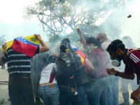Opposition activists clash with riot police during a protest march in Caracas on April 26, 2017. Protesters in Venezuela plan a high-risk march against President Maduro Wednesday, sparking fears of fresh violence after demonstrations that have left 26 dead in the crisis-wracked country. / AFP PHOTO / RONALDO SCHEMIDT (Photo credit should read RONALDO SCHEMIDT/AFP/Getty Images)