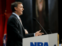 Chris Cox, executive director of the Institute for Legislative Action, the political and lobbying arm of the National Rifle Association, speaks during the annual meeting of members at the NRA convention Saturday, April 11, 2015, in Nashville, Tenn. Projected on a screen behind Cox is a picture of former Secretary of State Hillary Clinton. (AP Photo/Mark Humphrey