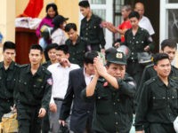 Released policemen (wearing dark uniforms) walk out from the communal house at Dong Tam commune, My Duc district in Hanoi on April 22, 2017. More than a dozen police and officials held hostage by Vietnamese villagers over a land dispute were released on April 22, state media reported, ending a week-long standoff that had gripped the country. / AFP PHOTO / STR (Photo credit should read STR/AFP/Getty Images)