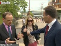 A BBC reporter tried to push aside a woman who interrupted him in the middle of a live, on-camera interview and wound up grabbing her breast.