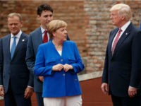 German Chancellor Angela Merkel talks with President Donald Trump during a family photo with G7 leaders at the Ancient Greek Theater of Taormina, during the G7 Summit, Friday, May 26, 2017, in Taormina, Italy. From left, European Council President Donald Tusk, Canadian Prime Minister Justin Trudeau, Merkel, and Trump. (AP Photo/Evan Vucci)