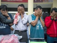 This photo taken on April 30, 2017 shows Indonesian police parading a group of men arrested for allegedly holding a 'gay party' in Surabaya, the second biggest city in Indonesia, the world's most populous Muslim-majority country. Officers busted 14 men holding the party in two hotel rooms in Surabaya, around midnight on April 29. / AFP PHOTO / JUNI KRISWANTO (Photo credit should read JUNI KRISWANTO/AFP/Getty Images)