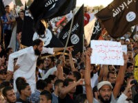 Supporters of the Jihadist group Ansar al-Sharia shout religious slogans while holding Al-Qaeda-affiliated flags to counter a demonstration by thousands of people against militias in the eastern city of Benghazi on September 21, 2012. Thousands of Libyans rallied against militias in the tense city of Benghazi, drowning out a protest by radical Salafists furious over a film and cartoons deemed offensive to Islam. Sign (R) reads 'Long live free Libya. We want a national army and security.' AFP PHOTO/ABDULLAH DOMA (Photo credit should read ABDULLAH DOMA/AFP/Getty Images)