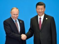 Russian President Vladimir Putin (L) praised his Chinese counterpart Xi Jinping's Silk Road initiative, which spans 65 countries representing 60 percent of the world population and around a third of global gross domestic product