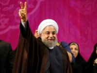 Iranian President Hassan Rouhani, who has comfortably won a second term, gestures during a campaign rally in Tehran on May 9, 2017