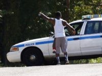 A resident gestures to a policeman as a police presence remains in a south Jackson, Miss., neighborhood, Thursday, Sept. 22, 2016, while lawmen continue to negotiate with a man suspected of holding about a dozen people against their will. Authorities believe all the hostages have been safely removed without a shot being fired, but the person suspected of holding the hostages remained inside a Mississippi boarding house. (AP Photo/Rogelio V. Solis)