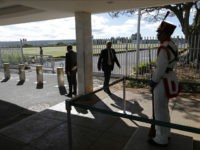 Security officers stand guard at the main entrance of the Alvorada Palace after a minor rammed a car through the gate Wednesday night, in Brasilia, Brazil, Thursday, June 29, 2017. Security forces detained a the minor who allegedly wanted to reach the presidential palace. A statement from the president's office says that around 7 p.m. Wednesday a vehicle drove at a high speed toward the Alvorada Palace. (AP Photo/Eraldo Peres)