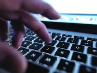 Man typing on a laptop computer. Science Photo Library / ABO