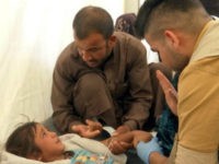 In this frame grab from video, a man comforts his daughter as a doctor treats her after she was taken ill with suspected food poisoning in the Hassan Sham U2 camp for displaced people located about 20 kilometers (13 miles) east of Mosul, Iraq, Tuesday, June 13, 2017. Iraq’s health minister, Adila Hamoud, told The Associated Press in Baghdad that 752 people had been taken ill and at least two died after they took part in a Monday night meal to break the Muslim dawn-to-dusk fasting during the holy month of Ramadan. (AP Photo/Balint Szlanko)