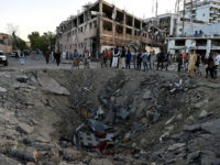 TOPSHOT - Afghan security forces and residents stand near the crater left by a truck bomb attack in Kabul on May 31, 2017. At least 80 people were killed and hundreds wounded May 31 when a massive truck bomb ripped through Kabul's diplomatic quarter, bringing carnage to the streets of the Afghan capital and shattering windows hundreds of metres away. / AFP PHOTO / WAKIL KOHSAR (Photo credit should read WAKIL KOHSAR/AFP/Getty Images)