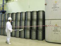 In this March 23, 2016 photo, a worker checks the radiation level on barrels in a storage of nuclear waste The Latest: Russian oil company says gas stations affected Photo