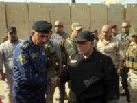 Iraq's Prime Minister Haider al-Abadi, center right, shakes hands with Lieutenant General Raid Shaker Jawlat, center left, the commander of Iraqi federal police upon his arrival in Mosul, Iraq, Sunday, July 9, 2017. Backed by the U.S.-led coalition, Iraq launched the operation to retake Mosul from Islamic State militants in October. (Iraqi Federal Police Press Office via AP)