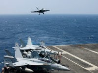 FILE - In this March 3, 2017 file photo, a U.S. Navy F18 fighter jet lands on the U.S. Navy aircraft carrier USS Carl Vinson (CVN 70) following a patrol off the disputed South China Sea. The USS Carl Vinson, which is steaming through the South China Sea, is just one of several high-profile displays of U.S. naval power as President Donald Trump's administration weighs options of how to reassure allies and respond to an assertive China. The current makeup of the aircraft carrier strike group suggests it may not carry out an anticipated freedom of navigation operation just yet. China has scoffed at U.S. patrols and stepped up its own presence. (AP Photo/Bullit Marquez, File)